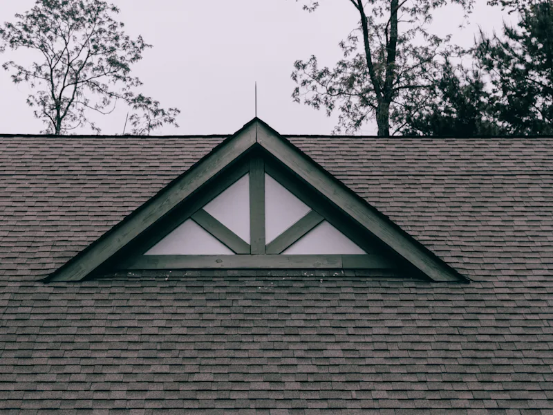 Decorative gable vent detail set into an asphalt shingle roof plane